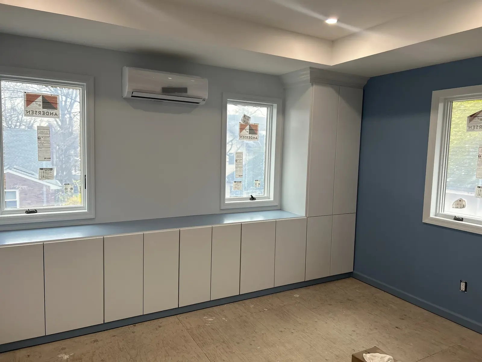 Room with blue accent wall and built-in base cabinets
