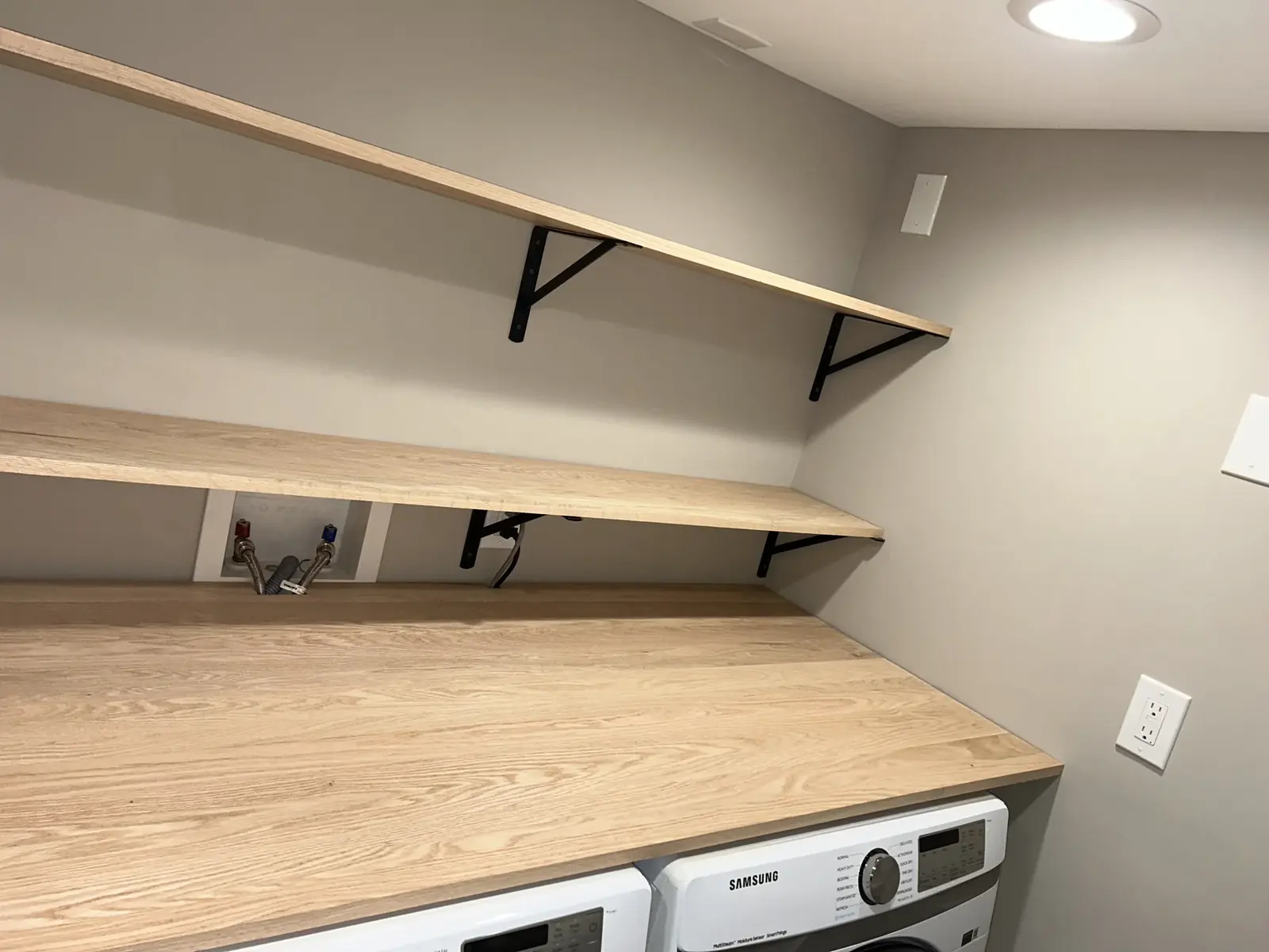 Finished laundry or utility area with shelving and wall finish work